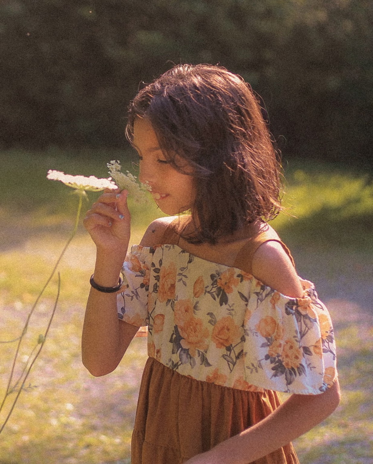 Child holding a flower in warm sunlight