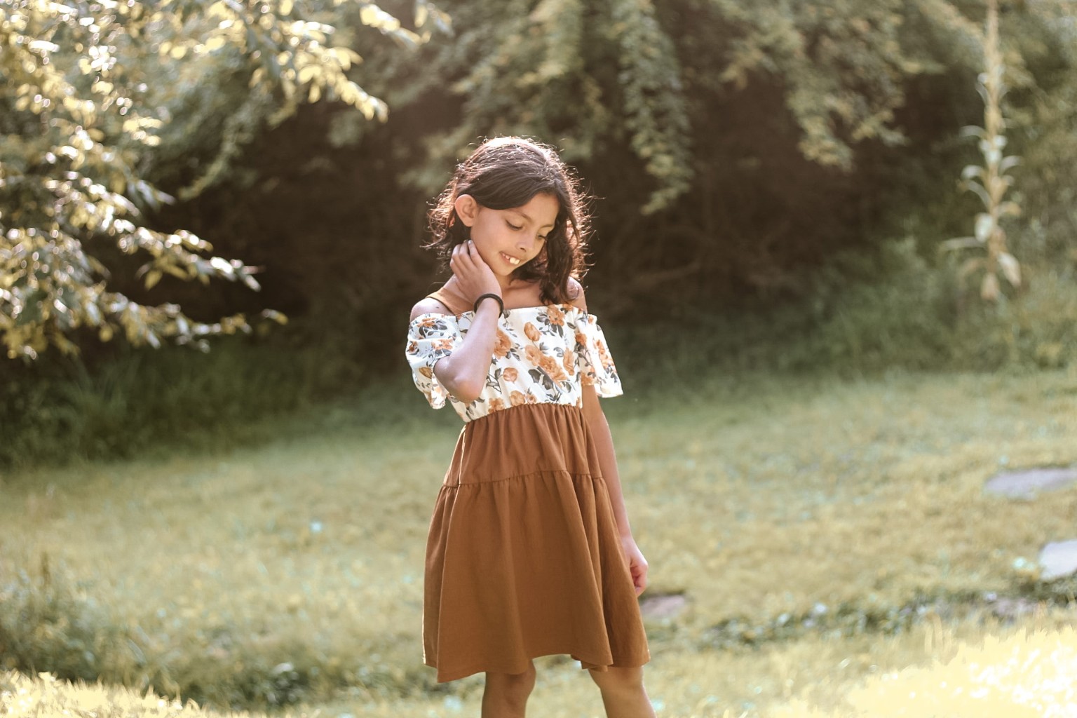 Child standing in a sunlit meadow