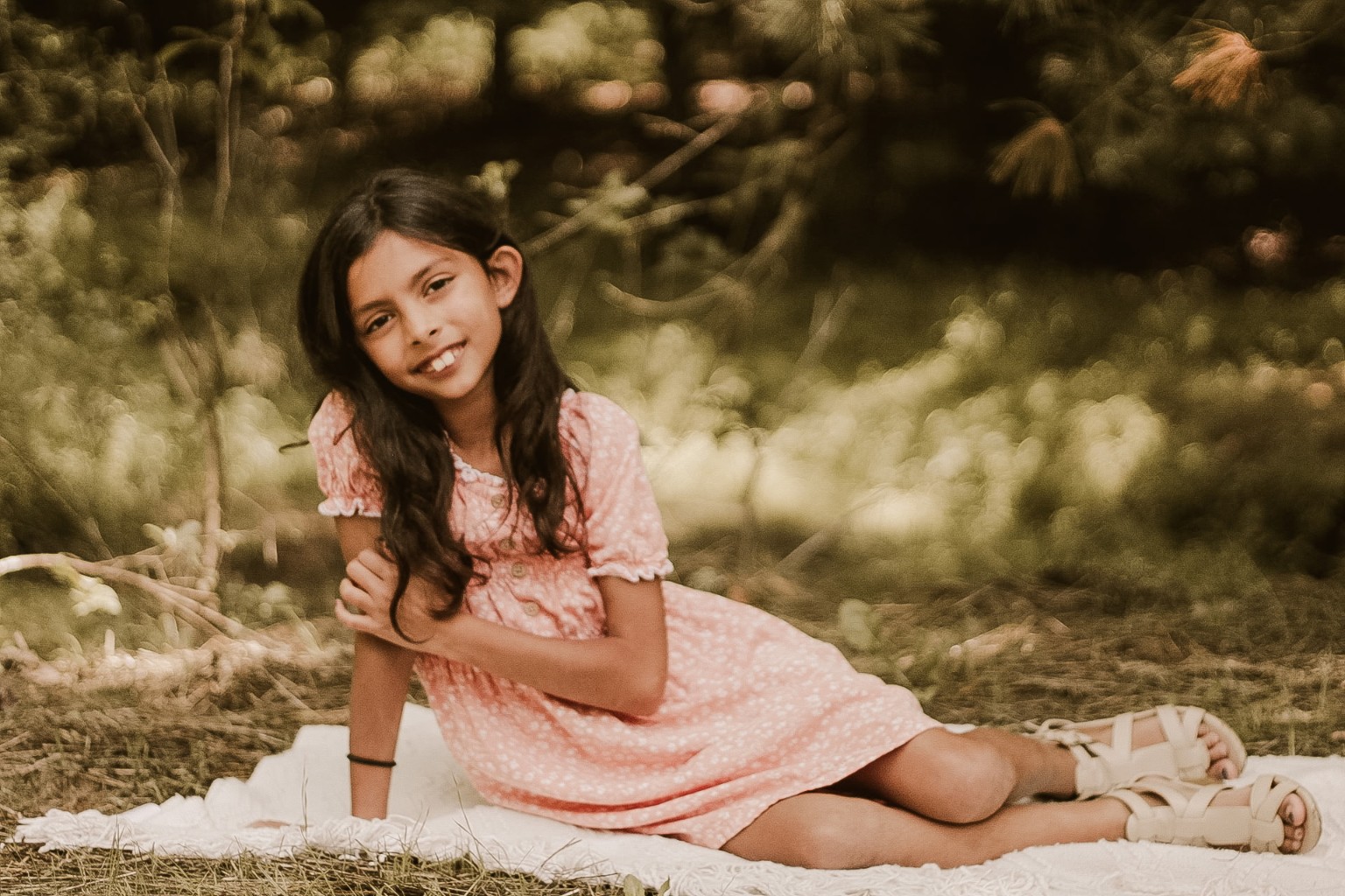 Child reclining on a blanket outdoors